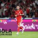 "Pemain Timnas Indonesia mengenakan jersey nomor 17 melakukan selebrasi gol pada pertandingan internasional, disaksikan ribuan penonton di stadion."